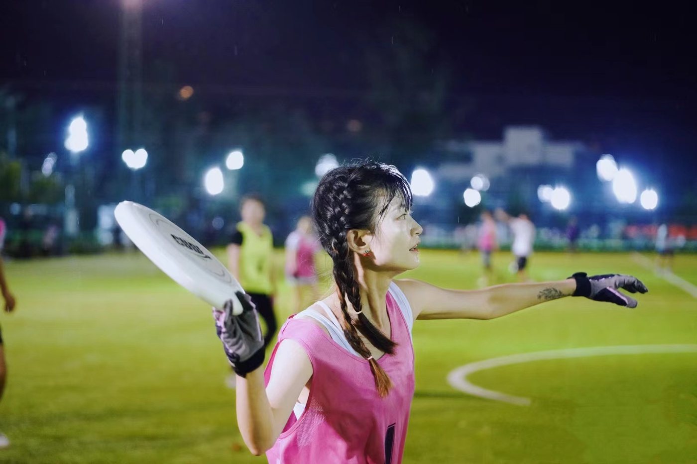 Serena catching a frisbee at a night game