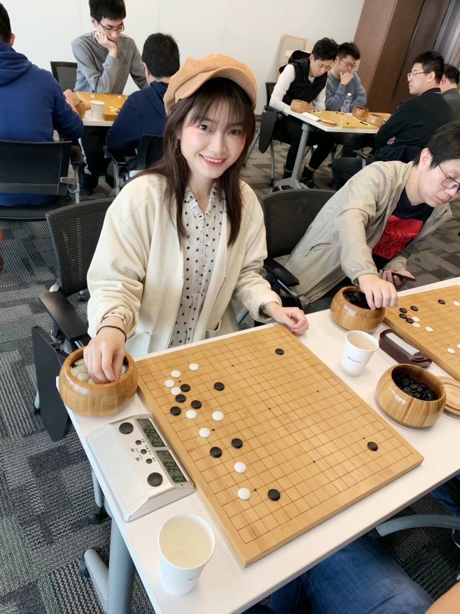 Serena smiling beside a Go board at a tournament