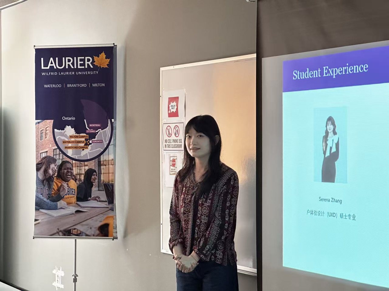 Serena presenting a Student Experience talk beside a Laurier banner